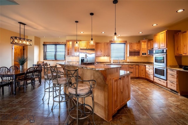 115AND117 Otter Creek Rd, Big Timber, MT 59011 - kitchen featuring appliances with stainless steel finishes, a center island, glass insert cabinets, a breakfast bar, and recessed lighting