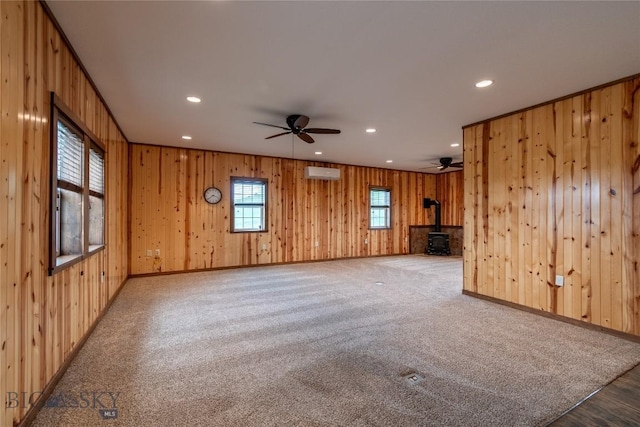 115AND117 Otter Creek Rd, Big Timber, MT 59011 - unfurnished living room featuring a wood stove, a wall mounted AC, recessed lighting, a ceiling fan, and wood walls