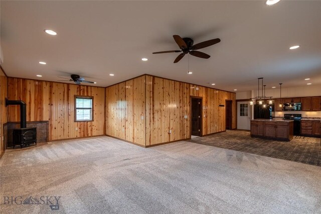 115AND117 Otter Creek Rd, Big Timber, MT 59011 - unfurnished living room with ceiling fan, wood walls, dark carpet, recessed lighting, and a wood stove