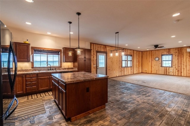 115AND117 Otter Creek Rd, Big Timber, MT 59011 - kitchen with freestanding refrigerator, a sink, dark wood-type flooring, a kitchen island, and wood walls