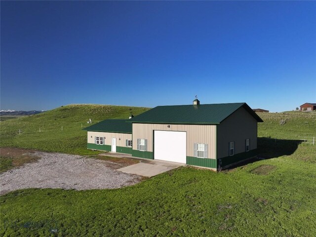 115AND117 Otter Creek Rd, Big Timber, MT 59011 - rear view of property with driveway, a yard, a detached garage, metal roof, and a chimney