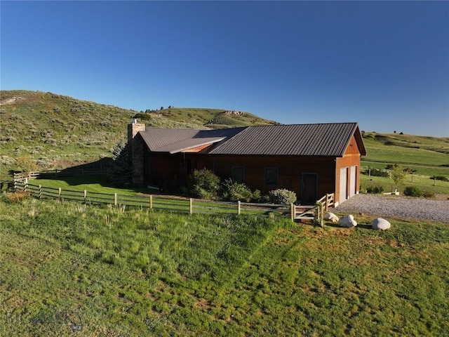 115AND117 Otter Creek Rd, Big Timber, MT 59011 - view of side of home with a chimney, a garage, metal roof, and a view of rural / pastoral area