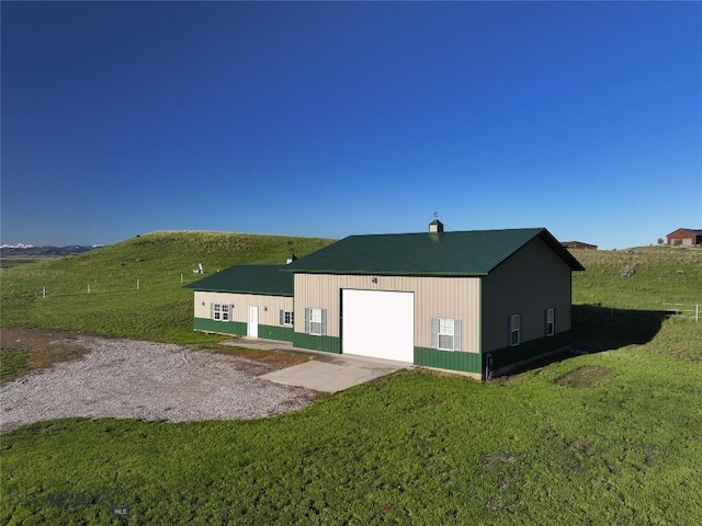 115AND117 Otter Creek Rd, Big Timber, MT 59011 - rear view of property with driveway, a yard, a detached garage, metal roof, and a chimney