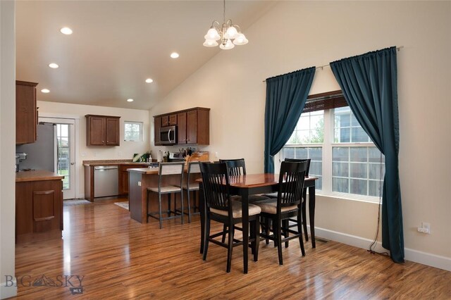 2206 Sturnella Ln, Belgrade, MT 59714 - dining space featuring recessed lighting, wood finished floors, baseboards, a chandelier, and high vaulted ceiling