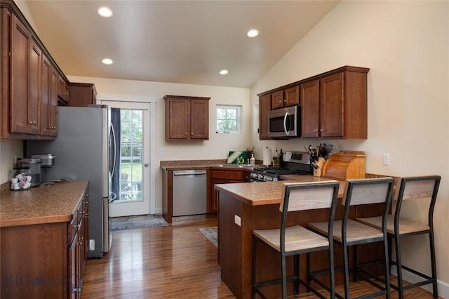 2206 Sturnella Ln, Belgrade, MT 59714 - kitchen featuring stainless steel appliances, a peninsula, recessed lighting, dark wood-style floors, and a breakfast bar area