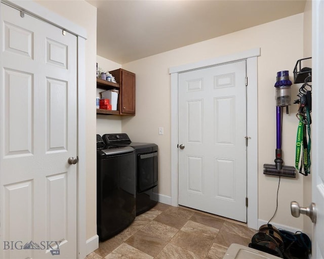 2206 Sturnella Ln, Belgrade, MT 59714 - laundry area with washer and dryer, cabinet space, baseboards, and light stone finish floors