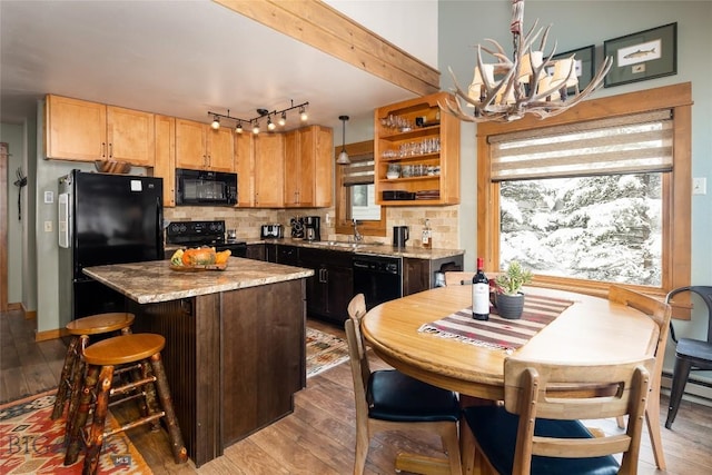 75 Rose Hip Cir, Big Sky, MT 59716 - kitchen featuring black appliances, a sink, light wood-style flooring, a center island, and a chandelier