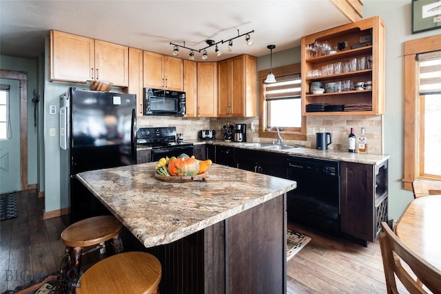 75 Rose Hip Cir, Big Sky, MT 59716 - kitchen with black appliances, a sink, light wood-style floors, and a kitchen breakfast bar