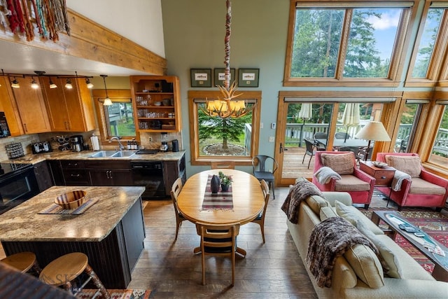 75 Rose Hip Cir, Big Sky, MT 59716 - kitchen with black appliances, a high ceiling, dark wood finished floors, healthy amount of natural light, and tasteful backsplash