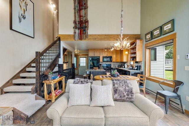 75 Rose Hip Cir, Big Sky, MT 59716 - living room featuring a high ceiling, light wood-type flooring, a chandelier, and stairway