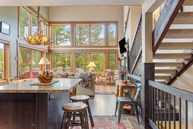 75 Rose Hip Cir, Big Sky, MT 59716 - kitchen with a chandelier, a high ceiling, open floor plan, a kitchen island, and hardwood / wood-style floors