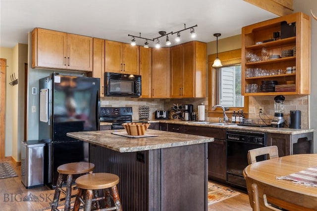 75 Rose Hip Cir, Big Sky, MT 59716 - kitchen featuring black appliances, light wood-style flooring, backsplash, and a kitchen island