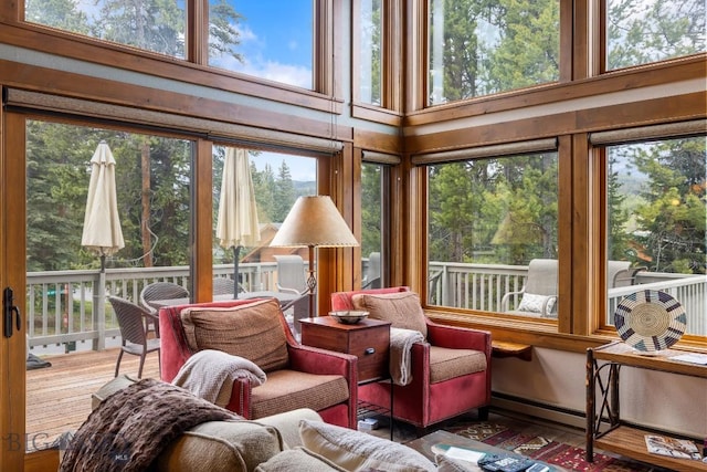 75 Rose Hip Cir, Big Sky, MT 59716 - sunroom / solarium featuring a wooden deck, plenty of natural light, hardwood / wood-style flooring, and a high ceiling