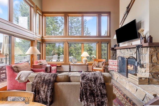 75 Rose Hip Cir, Big Sky, MT 59716 - living area featuring a towering ceiling, a stone fireplace, and plenty of natural light