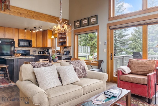 75 Rose Hip Cir, Big Sky, MT 59716 - living area with a chandelier, rail lighting, wood finished floors, and a towering ceiling