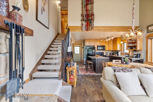 75 Rose Hip Cir, Big Sky, MT 59716 - living area featuring dark wood-type flooring, a chandelier, stairs, and a towering ceiling