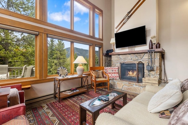 75 Rose Hip Cir, Big Sky, MT 59716 - living room with a stone fireplace, a high ceiling, plenty of natural light, and wood finished floors