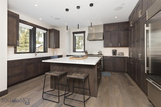 453 Outlook Trl, Big Sky, MT 59716 - kitchen featuring wall chimney exhaust hood, dark wood-type flooring, built in fridge, dark brown cabinetry, and recessed lighting