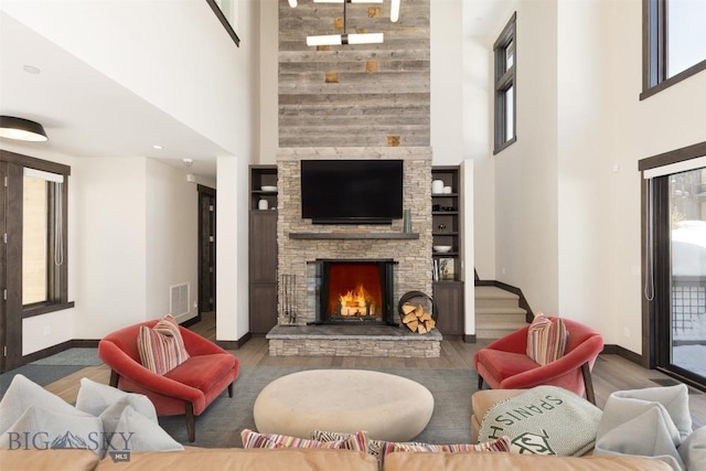 453 Outlook Trl, Big Sky, MT 59716 - living area with a fireplace, wood finished floors, baseboards, and a towering ceiling
