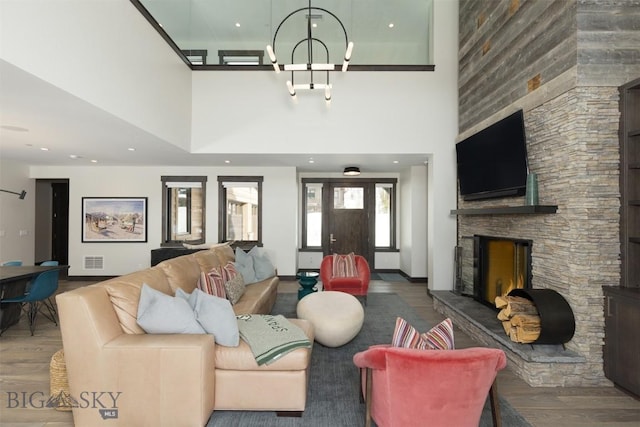 453 Outlook Trl, Big Sky, MT 59716 - living area with wood finished floors, a high ceiling, a stone fireplace, and a chandelier