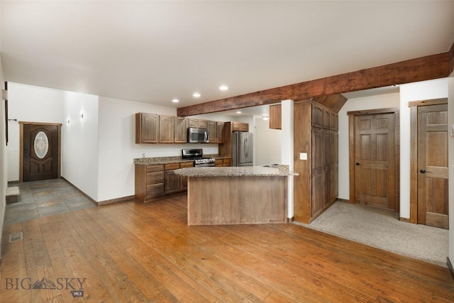 20 Prairie Grass B, Bozeman, MT 59718 - kitchen featuring appliances with stainless steel finishes, a peninsula, recessed lighting, wood finished floors, and beamed ceiling