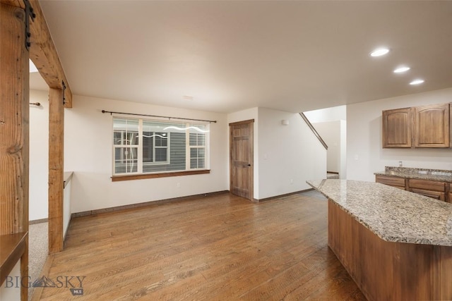 20 Prairie Grass B, Bozeman, MT 59718 - kitchen featuring wood finished floors, light stone counters, recessed lighting, and brown cabinets