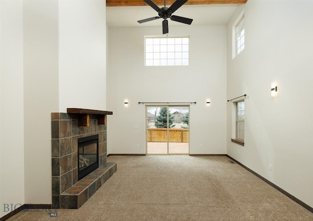20 Prairie Grass B, Bozeman, MT 59718 - unfurnished living room with a high ceiling, a ceiling fan, carpet floors, and a tile fireplace