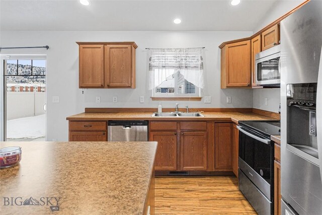3135 Mantle, Butte, MT 59701 - kitchen with stainless steel appliances, a sink, light wood-type flooring, recessed lighting, and brown cabinetry