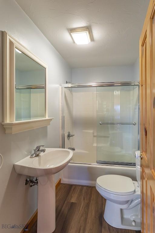 3 Dolly Varden Dr, Mcallister, MT 59740 - bathroom featuring toilet, wood finished floors, and combined bath / shower with glass door