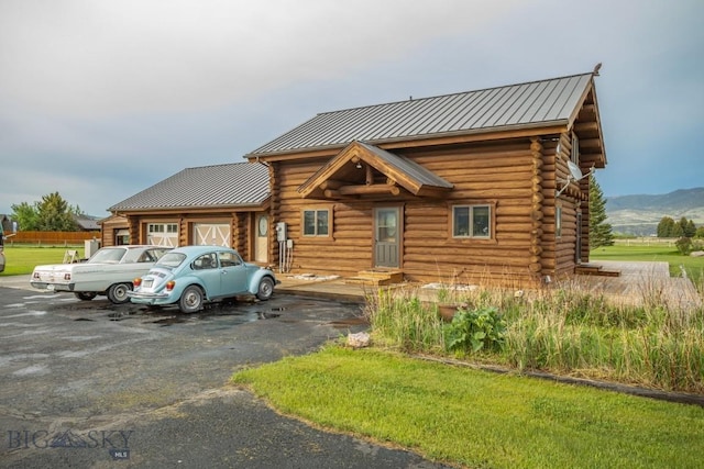 3 Dolly Varden Dr, Mcallister, MT 59740 - log home featuring log siding, an attached garage, a standing seam roof, metal roof, and a mountain view
