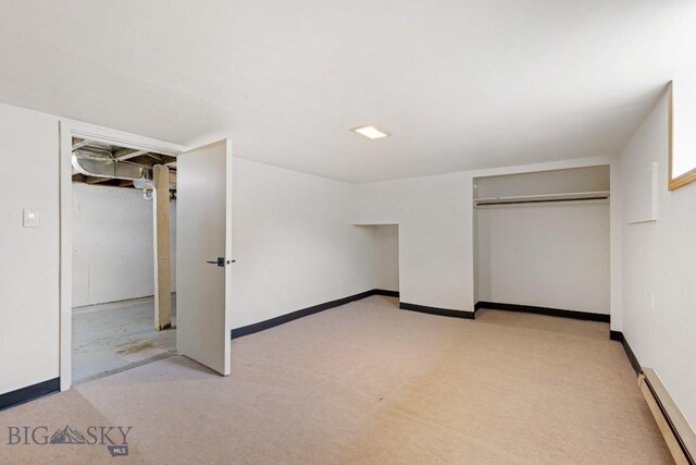 209 N 3rd, Bozeman, MT 59715 - unfurnished bedroom featuring a baseboard heating unit, light carpet, a closet, and baseboards