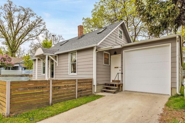 209 N 3rd, Bozeman, MT 59715 - view of front of property featuring a chimney, concrete driveway, a garage, and a shingled roof