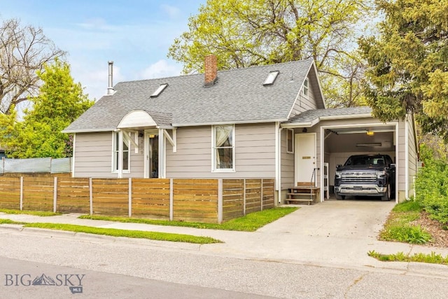 209 N 3rd, Bozeman, MT 59715 - view of front of property featuring an attached garage, concrete driveway, a chimney, a fenced front yard, and a shingled roof