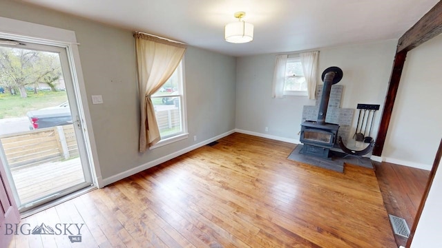 209 N 3rd, Bozeman, MT 59715 - unfurnished living room with hardwood / wood-style floors, a wood stove, and baseboards