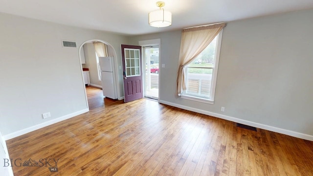209 N 3rd, Bozeman, MT 59715 - spare room featuring baseboards, arched walkways, and light wood finished floors