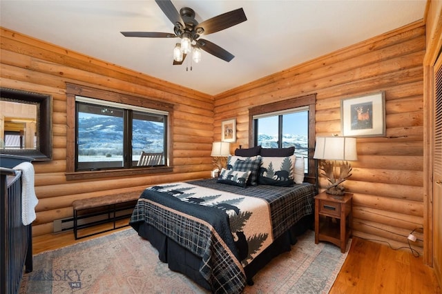 198 E River Rd, Emigrant, MT 59027 - bedroom featuring light wood-style flooring, log walls, baseboard heating, and ceiling fan
