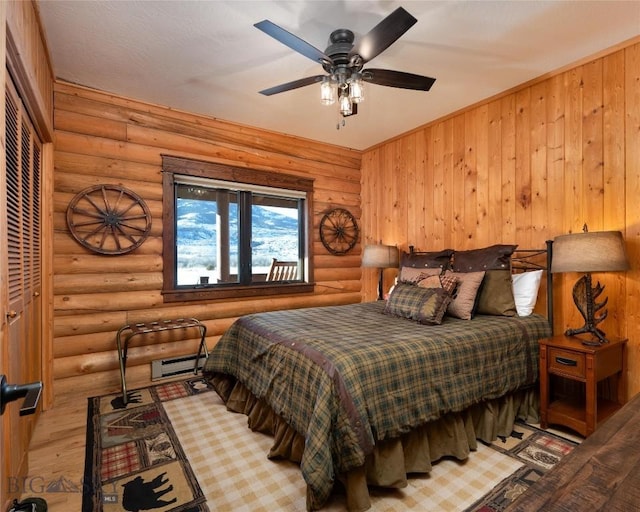 198 E River Rd, Emigrant, MT 59027 - bedroom featuring log walls, baseboard heating, and wood finished floors