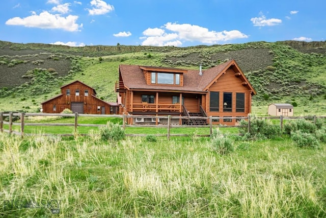 198 E River Rd, Emigrant, MT 59027 - back of house featuring log exterior, a barn, a garage, an outdoor structure, and a mountain view