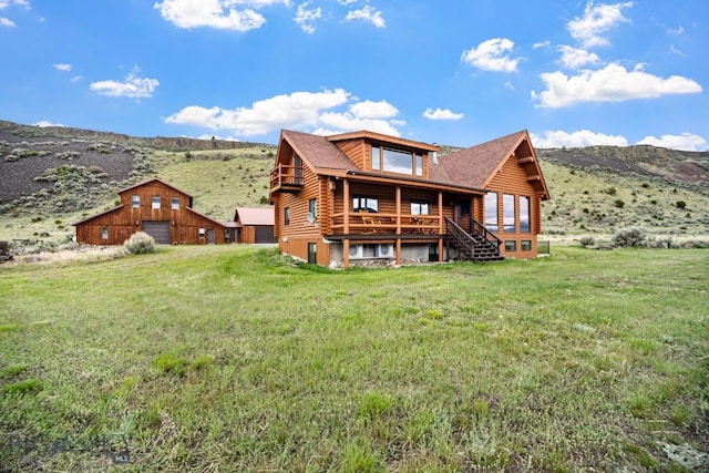 198 E River Rd, Emigrant, MT 59027 - rear view of house featuring log siding, a yard, a mountain view, and a garage