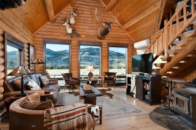 198 E River Rd, Emigrant, MT 59027 - living area with an AC wall unit, a wood stove, wooden ceiling with exposed beams, wood finished floors, and high vaulted ceiling