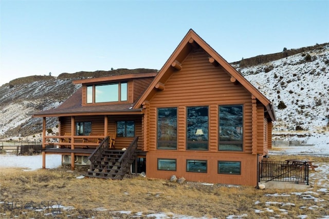 198 E River Rd, Emigrant, MT 59027 - snow covered rear of property with log exterior, stairs, and a mountain view