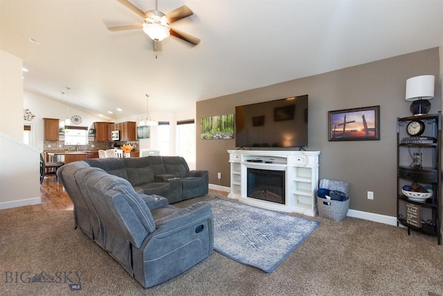 2008 Avocet Ct, Belgrade, MT 59714 - living room featuring ceiling fan, carpet, lofted ceiling, baseboards, and a glass covered fireplace