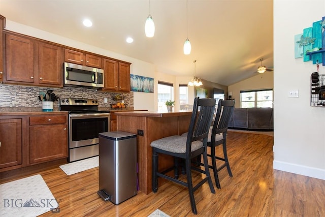 2008 Avocet Ct, Belgrade, MT 59714 - kitchen with stainless steel appliances, lofted ceiling, plenty of natural light, wood finished floors, and backsplash