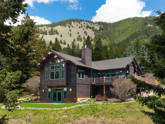 250 Petes Way, Big Sky, MT 59730 - back of property featuring a chimney, a lawn, a mountain view, and french doors