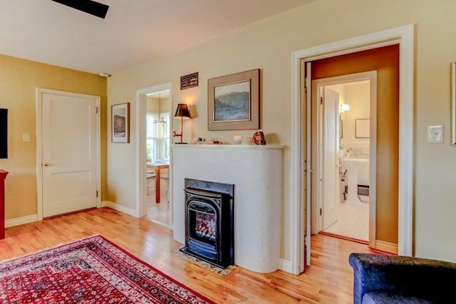 923 W Clark St, Livingston, MT 59047 - living area with light wood-style flooring, baseboards, and a glass covered fireplace
