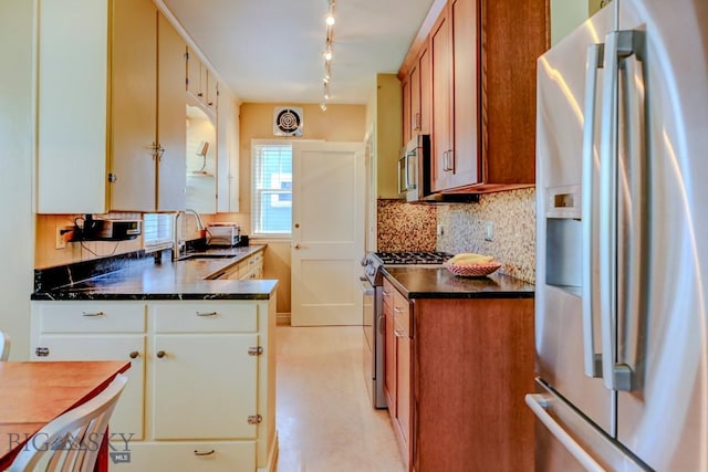 923 W Clark St, Livingston, MT 59047 - kitchen featuring stainless steel appliances, a sink, backsplash, brown cabinets, and rail lighting
