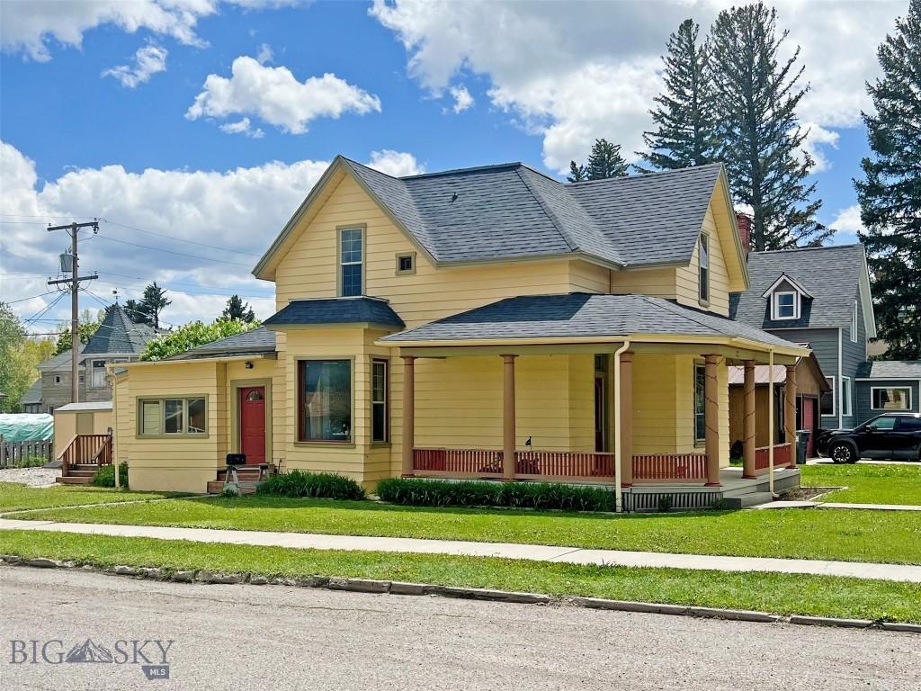 406 S Idaho St, Dillon, MT 59725 - view of front facade featuring a porch, a front lawn, and a shingled roof