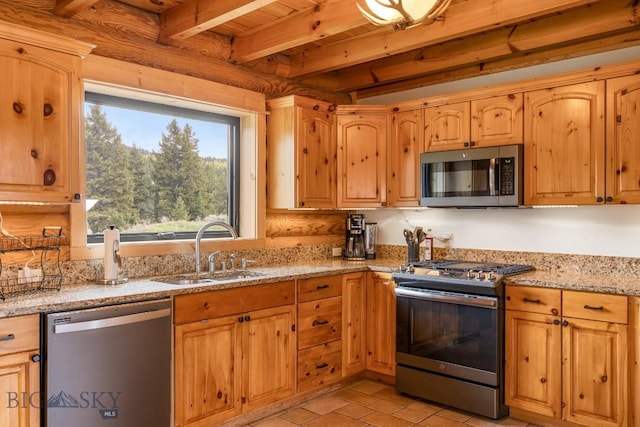 1266 Ousel Falls Rd, Big Sky, MT 59716 - kitchen featuring stainless steel appliances, a sink, beam ceiling, light stone countertops, and light tile patterned floors