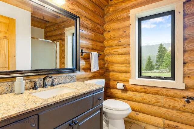 1266 Ousel Falls Rd, Big Sky, MT 59716 - bathroom featuring rustic walls, vanity, toilet, plenty of natural light, and an enclosed shower