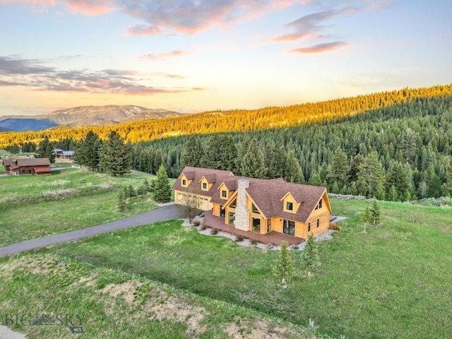 1266 Ousel Falls Rd, Big Sky, MT 59716 - aerial view at dusk of a wooded view and a mountain view